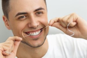 Patient flossing his teeth