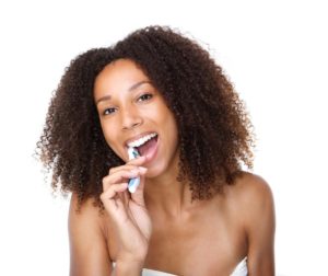 Young black female brushing her teeth