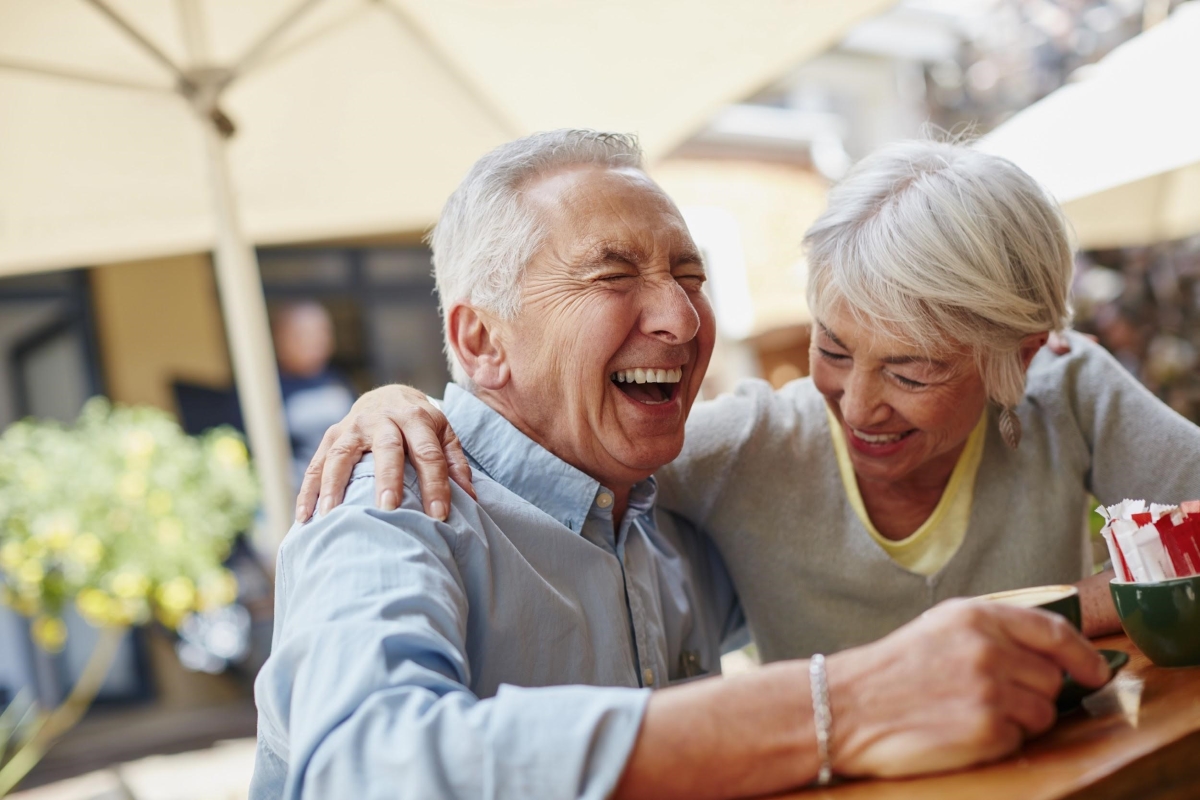 Happy older couple laughing outside at a restaurant